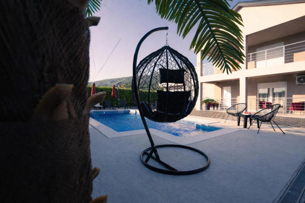 a bird cage sitting next to a pool at Villa Laguna Mostar in Mostar