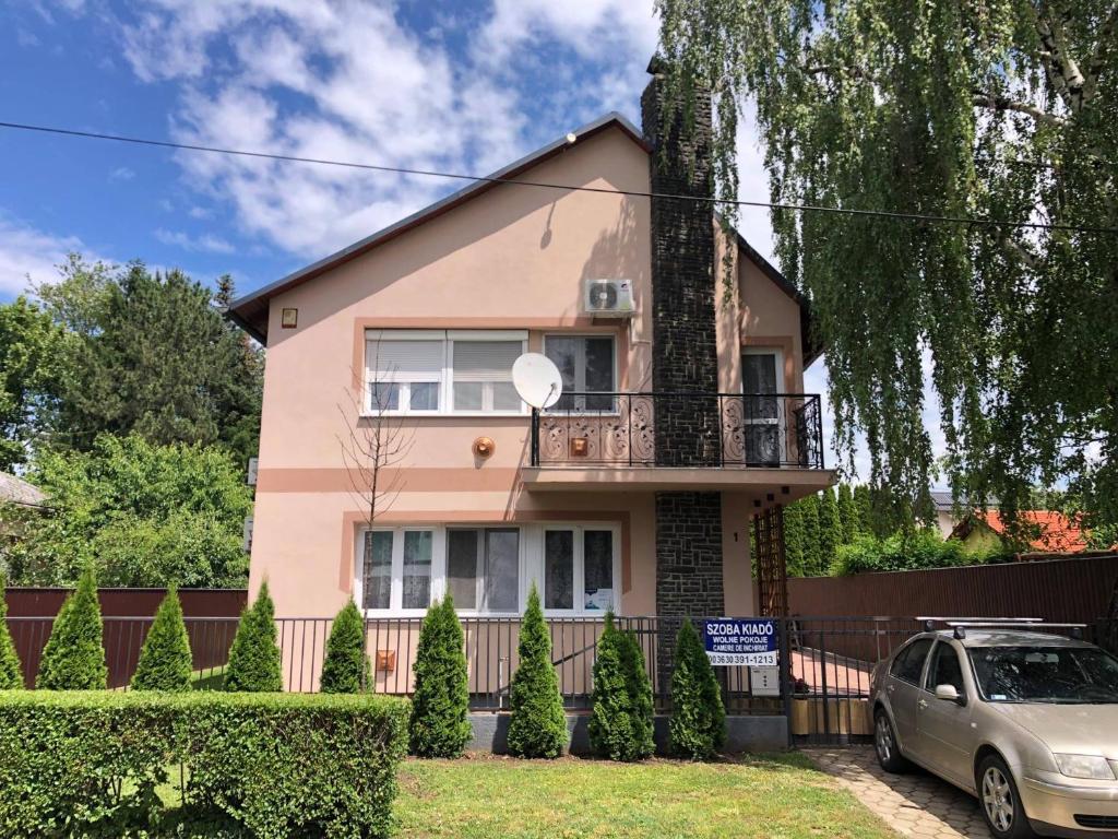 a pink house with a car parked in front of it at Árpád Vendégház in Hajdúszoboszló