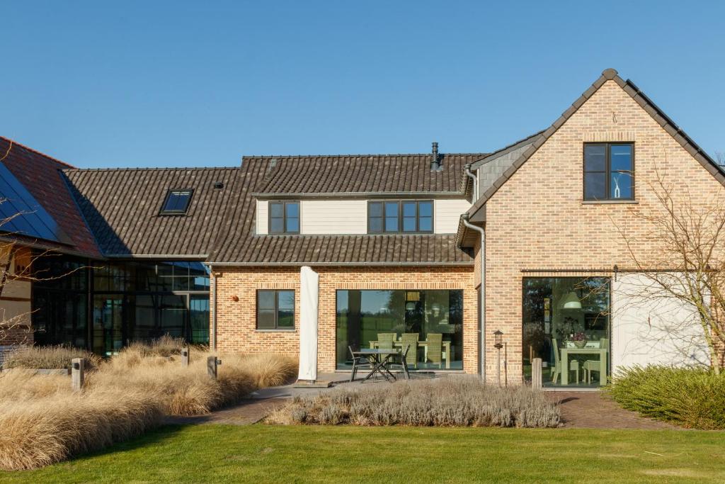 a house with large windows and a patio at Vakantiewoning Kastijd Kortessem - Haspengouw in Kortessem