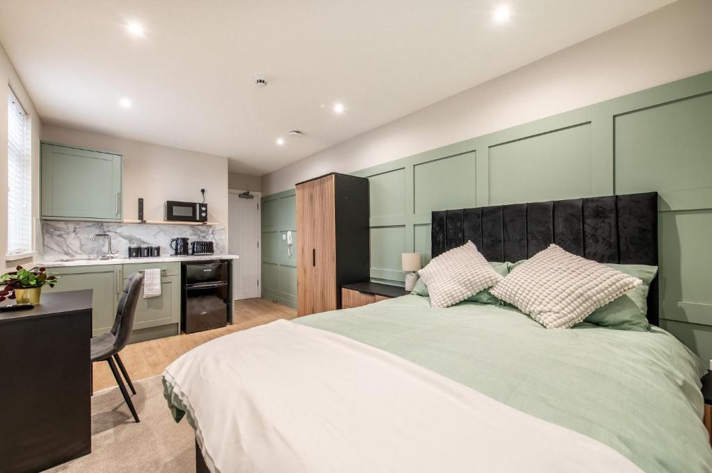 a bedroom with a large bed and a kitchen at Gillingham Luxury, LNG GRAIN, Workers, Parking, Flexible Weekly Deals in Gillingham
