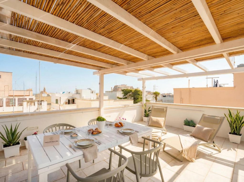 a patio with a table and chairs on a roof at Terrazza San Martino Private Terrace Stay in Monopoli