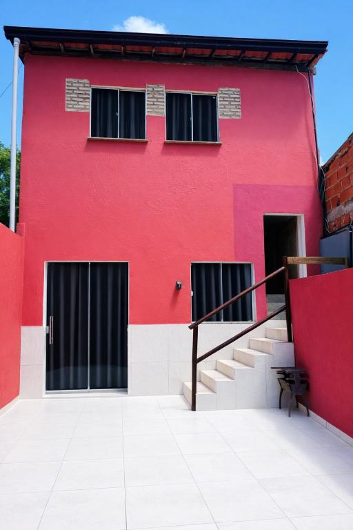a red building with black doors and stairs at Casa Adriê in Itacaré