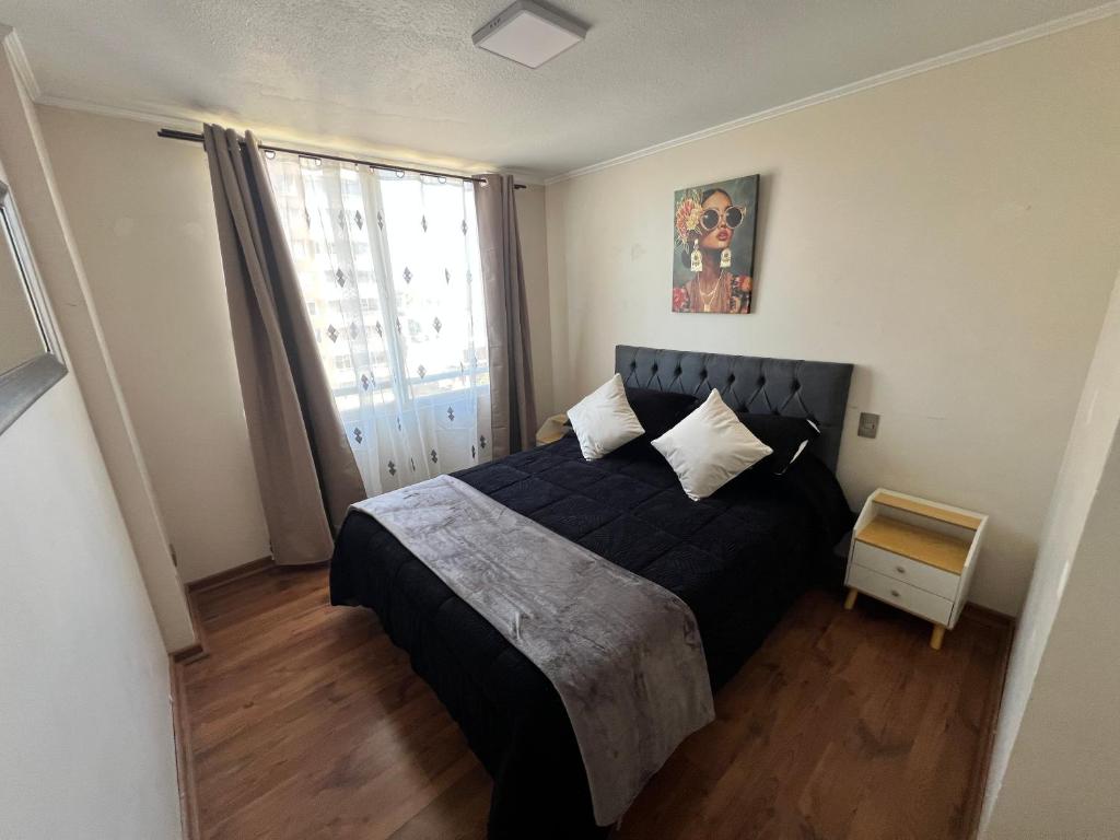 a bedroom with a black bed and a window at Mar & Costa Valparaíso in Valparaíso