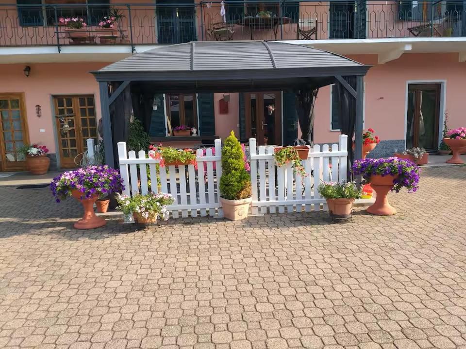 ein kleines Gebäude mit weißem Zaun und Topfpflanzen in der Unterkunft Ca' Susy in Samone