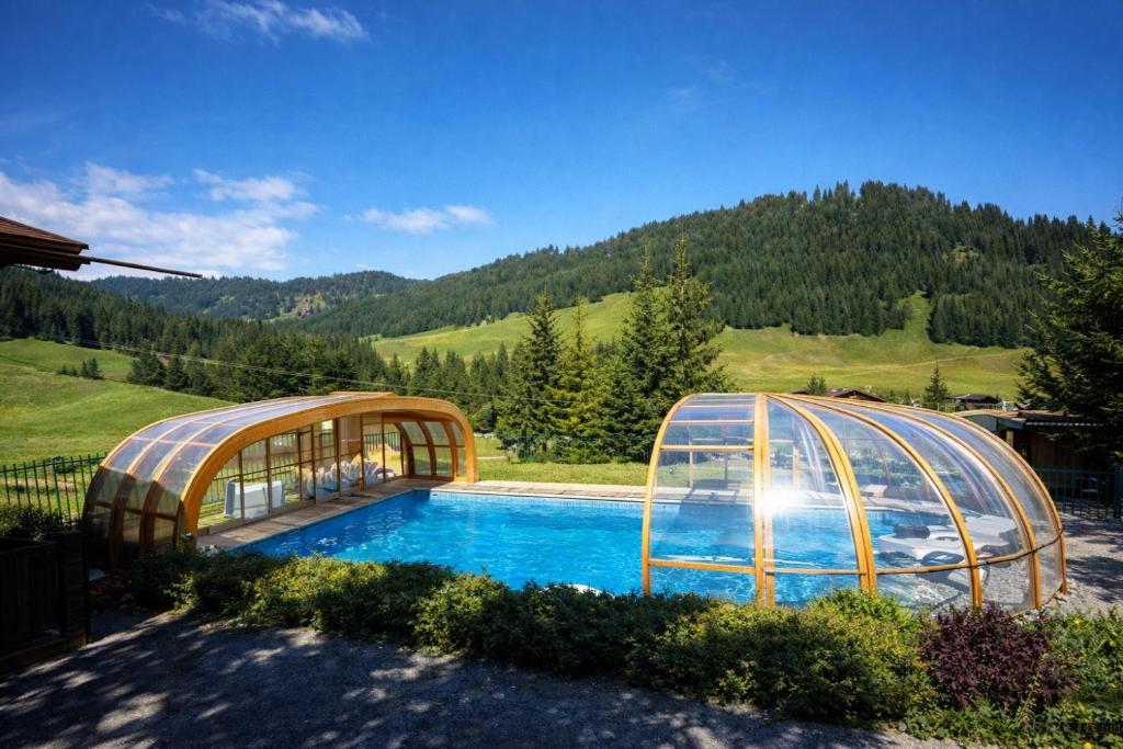 two domes over a swimming pool in a yard at Hôtel Chalet Alpage in La Clusaz