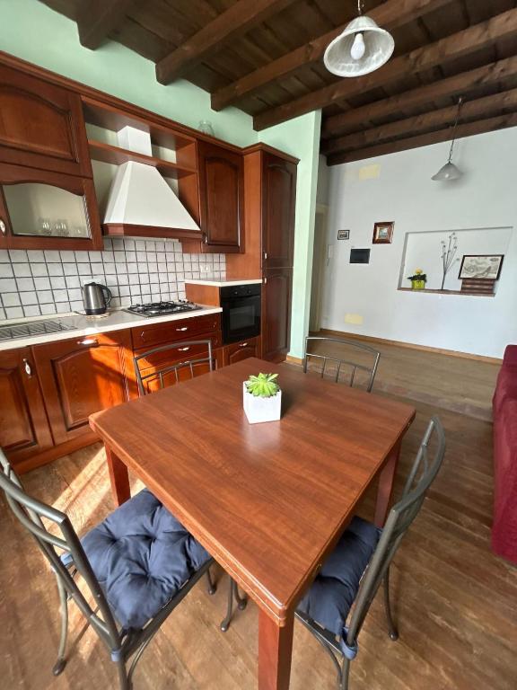 a kitchen with a wooden table and chairs at Casa La Torretta in Ceva