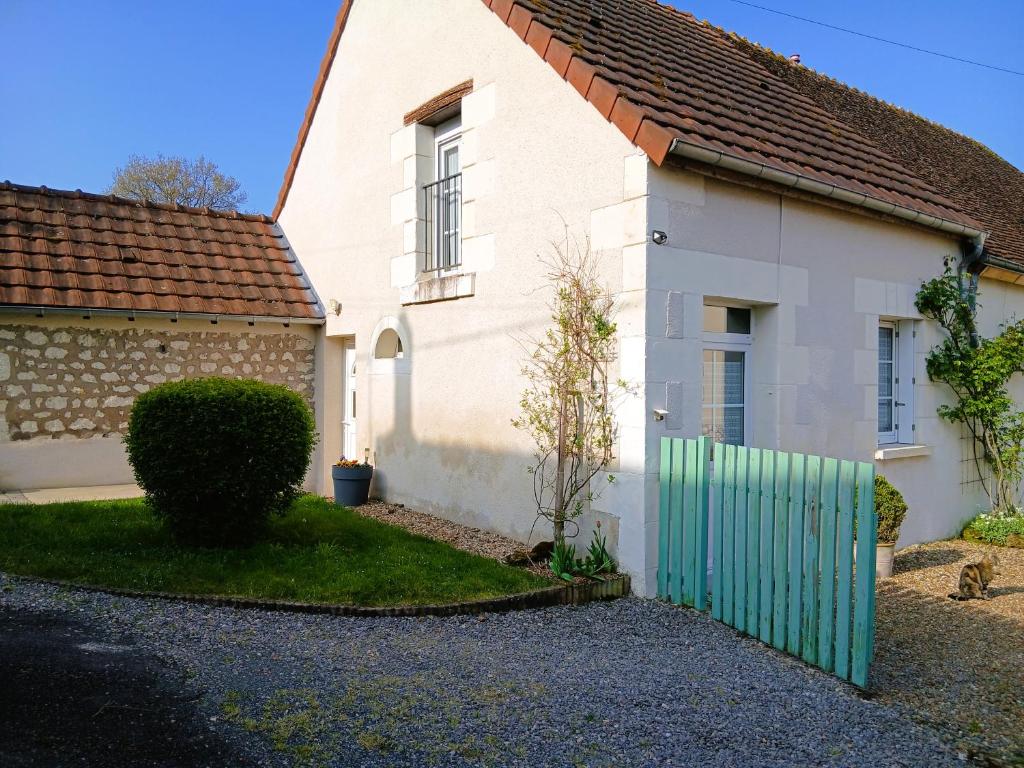 a white house with a green fence in front of it at Gite Chambres d Hotes des Péguets in Faverolles