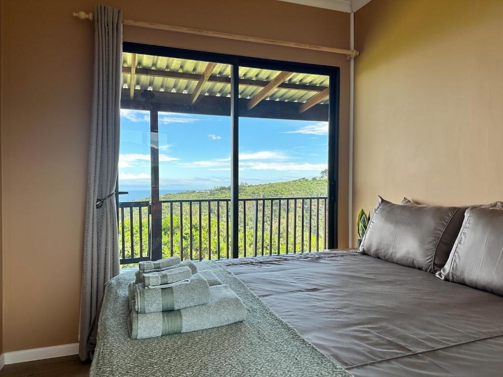 a bedroom with a large window with a bed and a balcony at Wilderness Escape with breathtaking Views in Wildernis