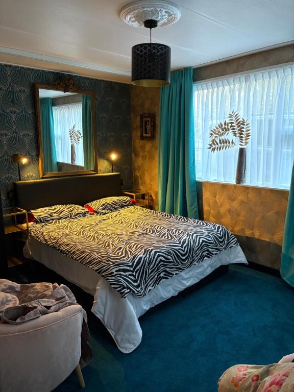a bedroom with a bed with a zebra print blanket at Amstelmeer Kamer in Westerland