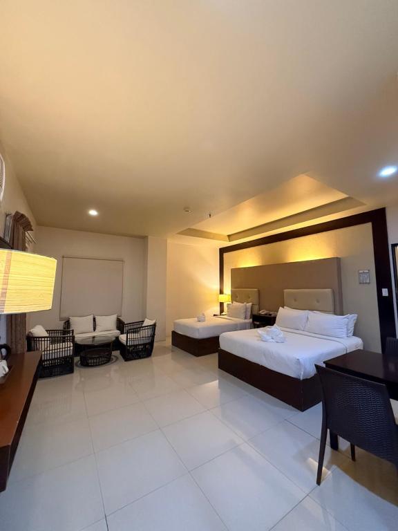 a hotel room with two beds and a couch at Sierra Hotel in Dumaguete