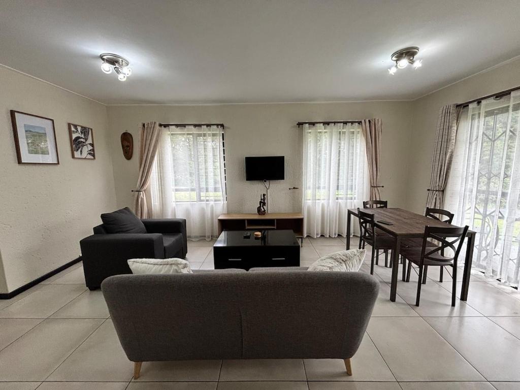 a living room with a couch and a table at Nestled sanctuary in Northriding