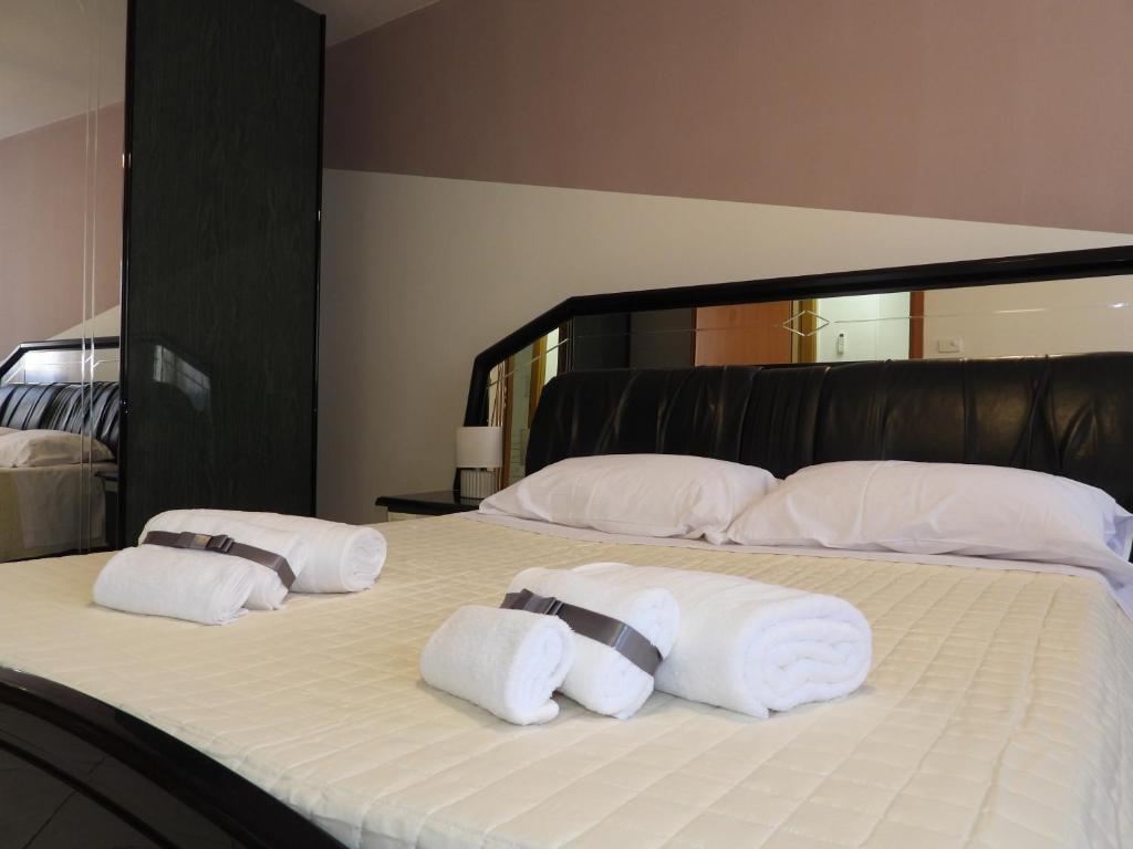 a bed with three pillows and towels on it at Rosario House in Comacchio
