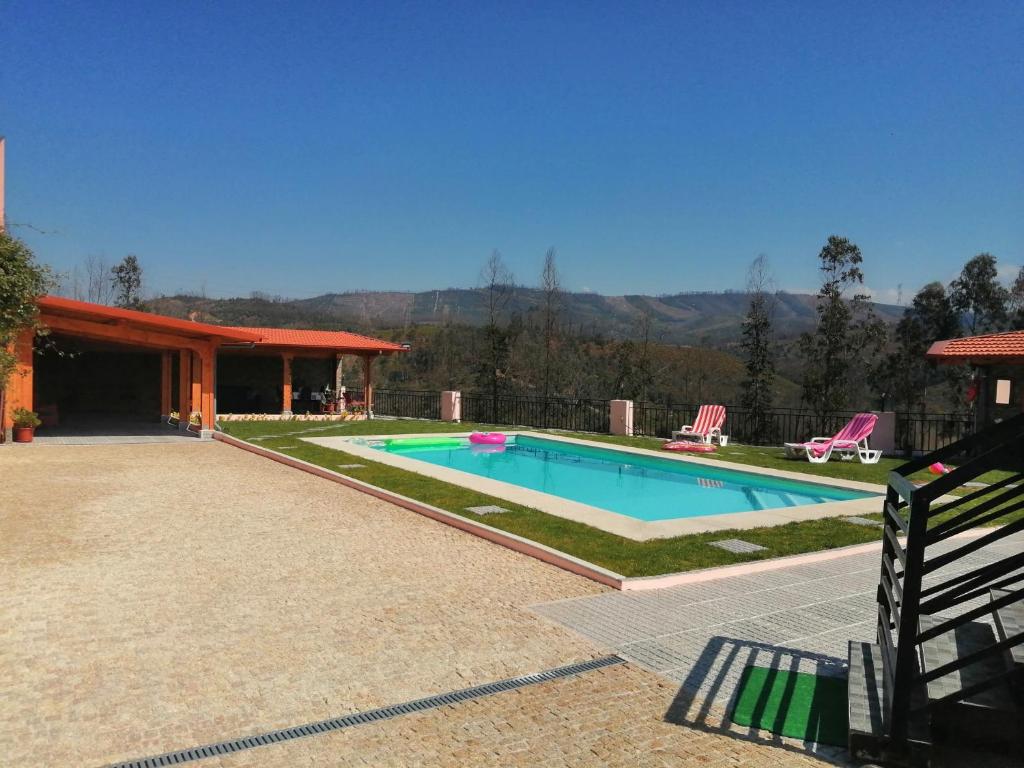 a swimming pool with two lawn chairs and a house at Eucalyptus Pink House in Covelo