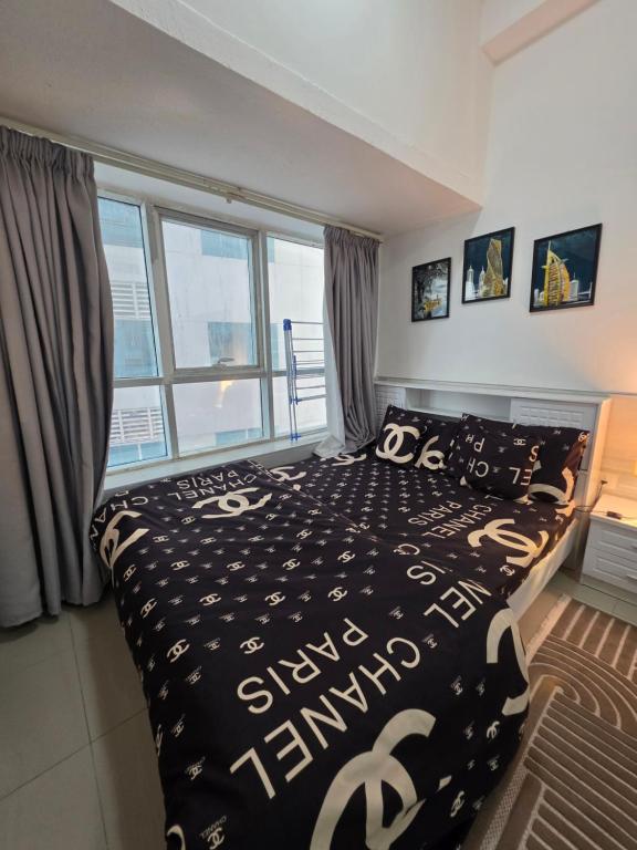 a bedroom with a bed with a black and white comforter at Ajman Studio Downtown B2OO7 in Ajman 