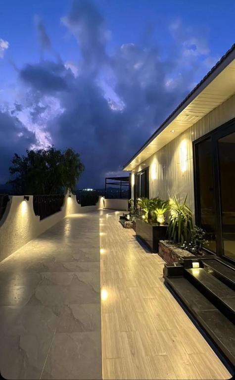 a balcony of a house at night with lights at شاليهات الحدبان - Al Hadban Chalets in Ash Shafa