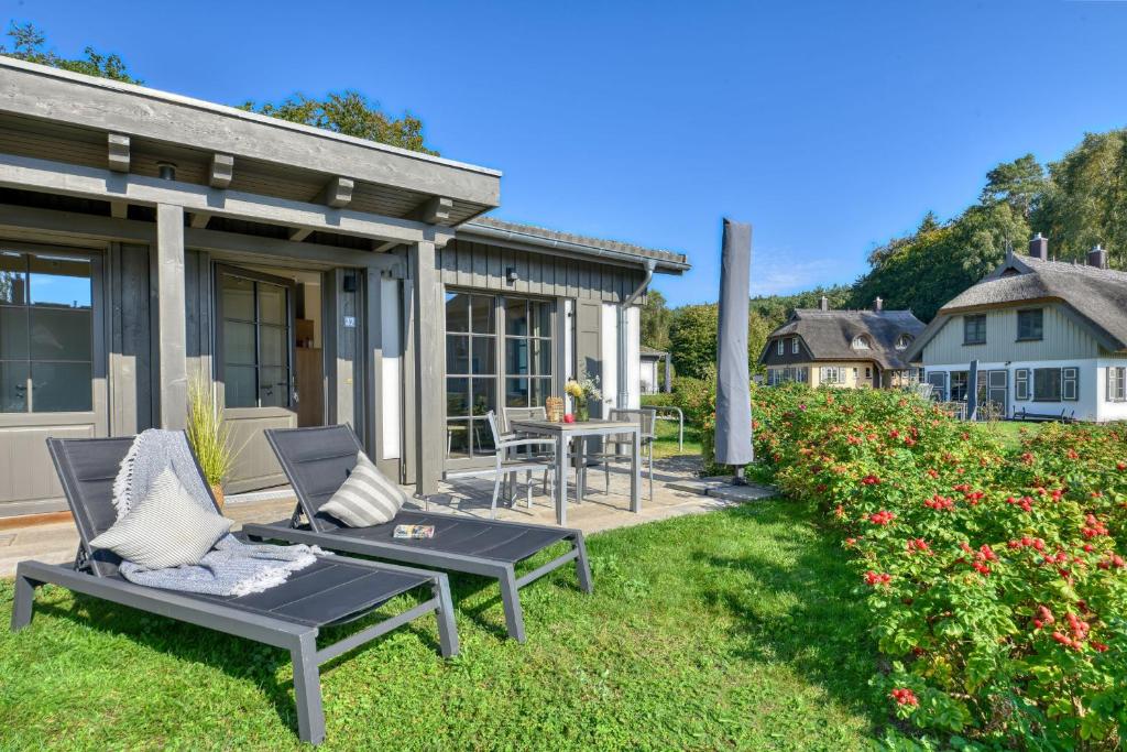 a patio with two lounge chairs and a table at Ferienhaus Strandbude Feriendorf 32 Klein Stresow Rügen by ruyastay in Putbus