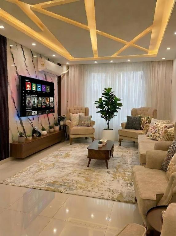 a large living room with couches and a tv at pyramids view luxury apartment in ‘Ezbet `Abd el-Ḥamîd