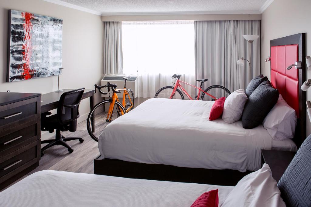 - une chambre d'hôtel avec 2 lits, un bureau et des vélos dans l'établissement Hotel Universel Alma, à Alma