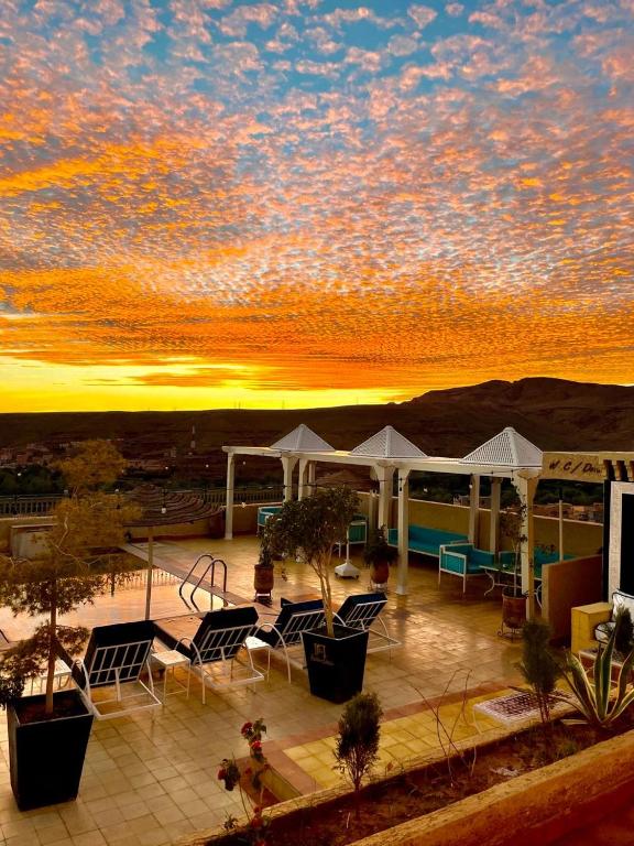 a view of a patio with chairs and a sunset at Ksar Sultan Dades - Dades Valley Retreat in Boumalne Dades
