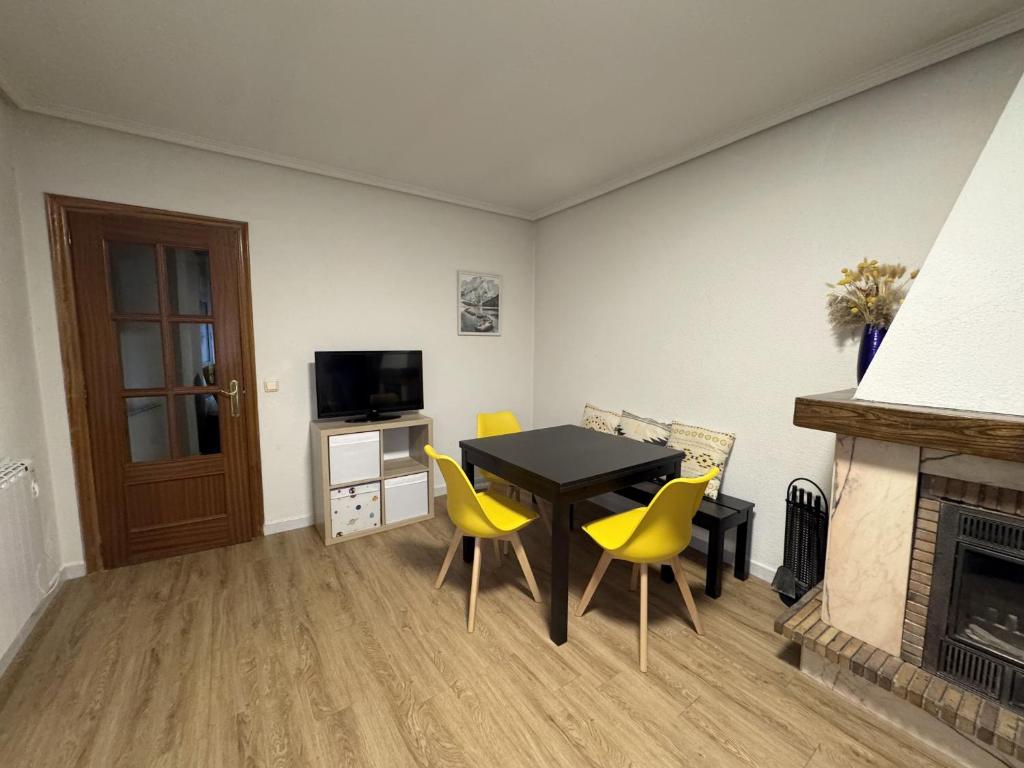 a living room with a table and chairs and a fireplace at Siente Riaño in Riaño