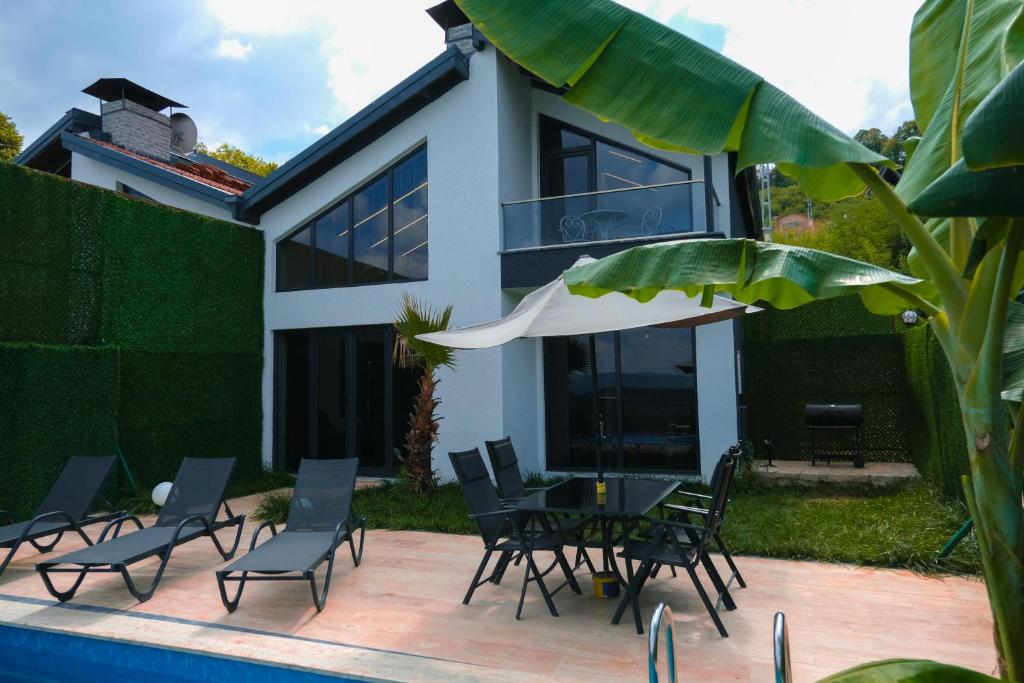 a house with a patio with chairs and an umbrella at Sapancamodern 2 in Sapanca