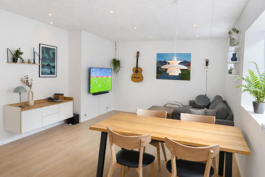 a living room with a wooden table and chairs at Rogvi's new appartment in Klaksvík