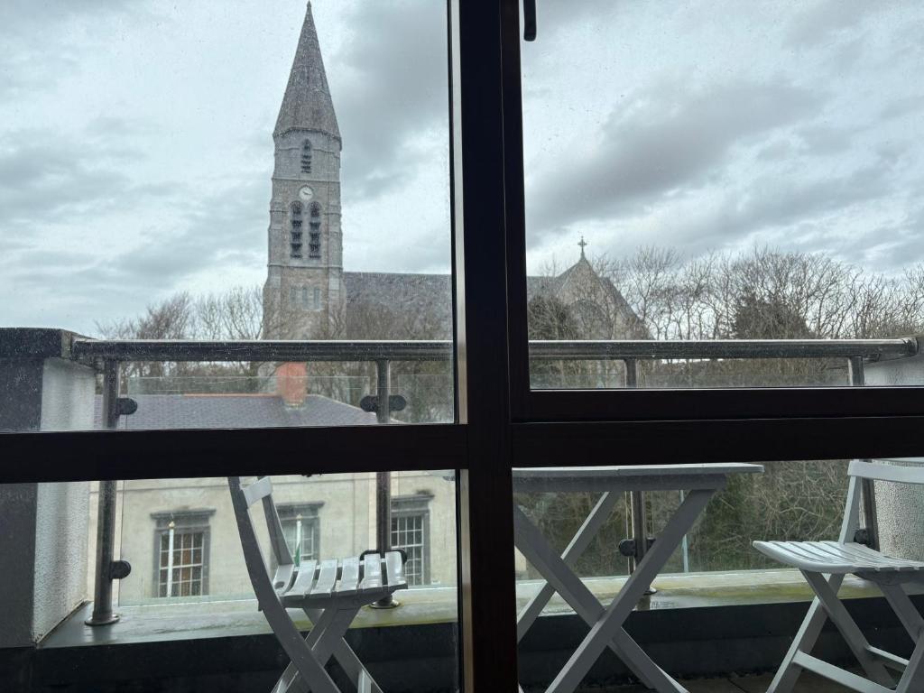 a view from a window of a church with a clock tower at Courthouse View Penthouse 1 in Clifden