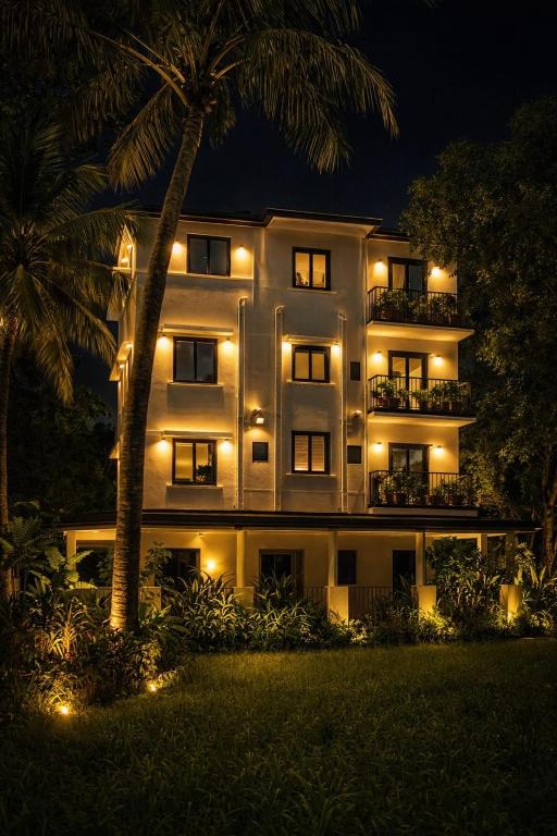 a lit up building with a palm tree in front of it at 88 villaggio Edappally in Edappally