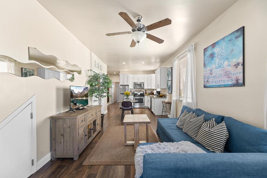 a living room with a blue couch and a ceiling fan at Marvelous Midtown Stay with a Modern Twist in Sacramento