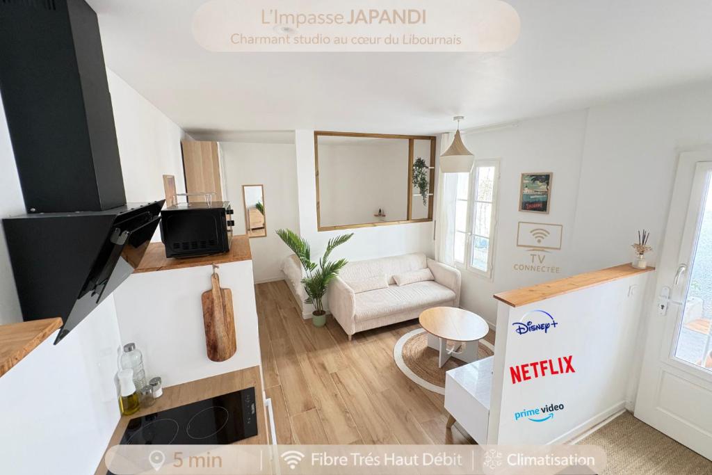 a living room with a white couch and a table at Le Japandi Maison confortable et calme à Libourne in Libourne