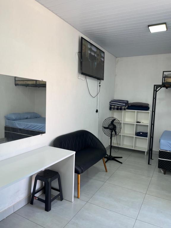 a room with a table and a chair and a tv at Kitnet aconchegante próximo a unesp in Botucatu