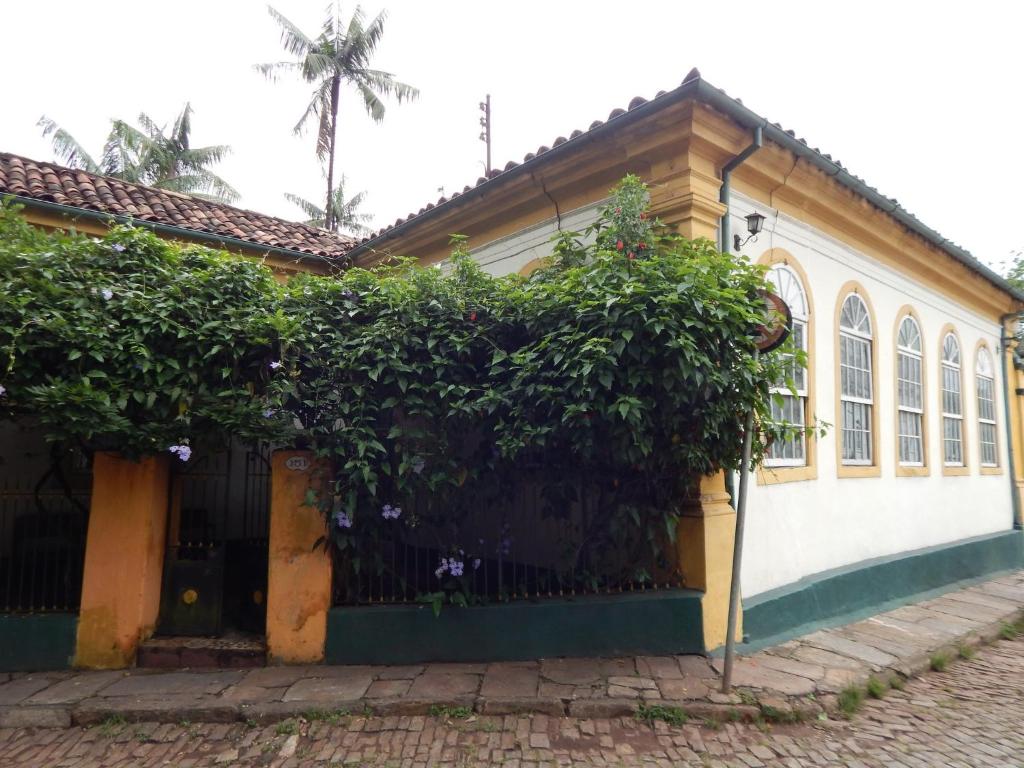 a house with a fence and trees in front of it at Pouso das Glicínias - B&B in Ouro Preto