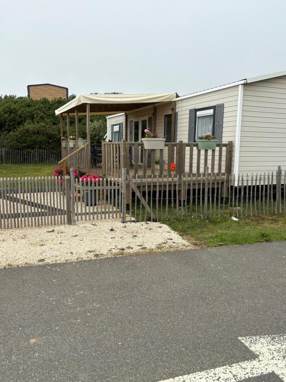 a house with a fence in front of it at Bungalow 6 personnes in Équihen-Plage
