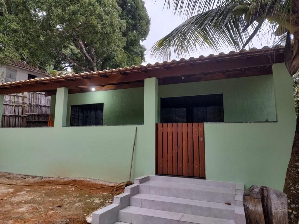 a green house with stairs leading to the front door at Eloá Mar's Corner in Angra dos Reis