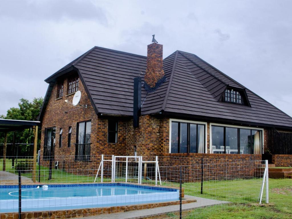 a house with a pool in front of it at Vaal Dam Getaway in Denysville