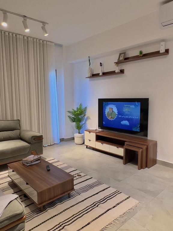 a living room with a flat screen tv on a wall at دقيقه للبحيره أقامه فندقيه مدينتي بريفادو madinaty privado in Madinaty