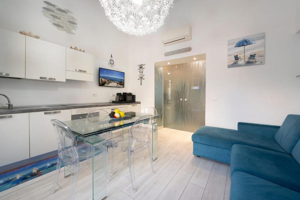 a kitchen with a glass table and a blue couch at Smeraldo in Palau