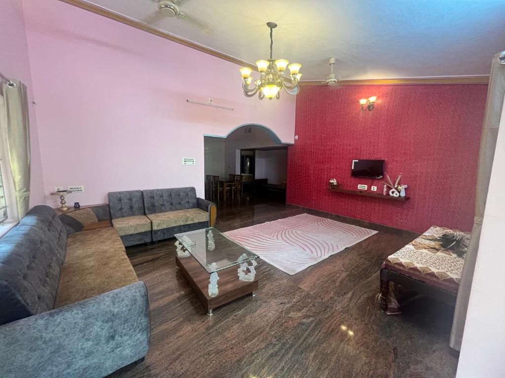 a living room with a couch and a red wall at Lake View in Kundapur