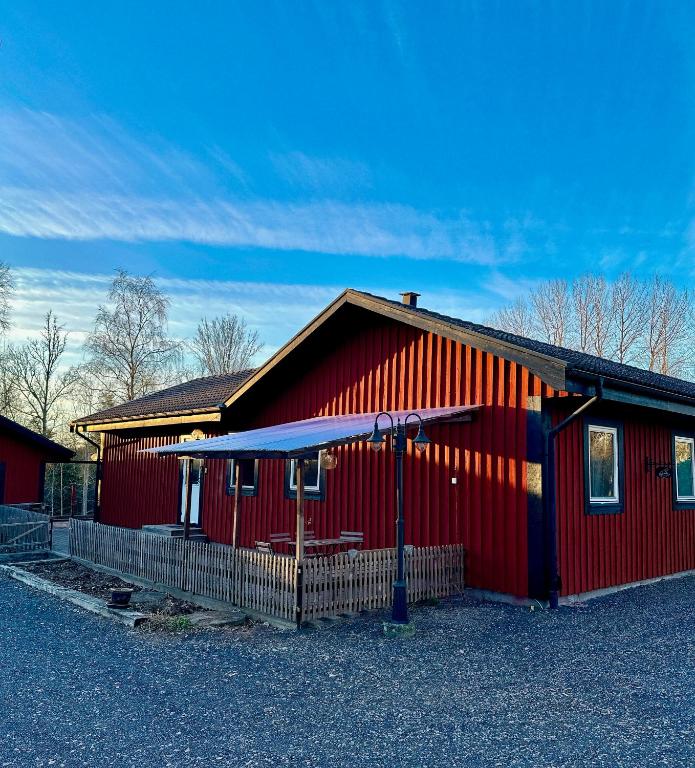 a red building with a blue canopy in front of it at Barts house in Länshult