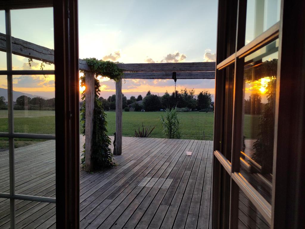 a view of a deck from a house with the sunset at Gîtes du vrai monde in Fillinges