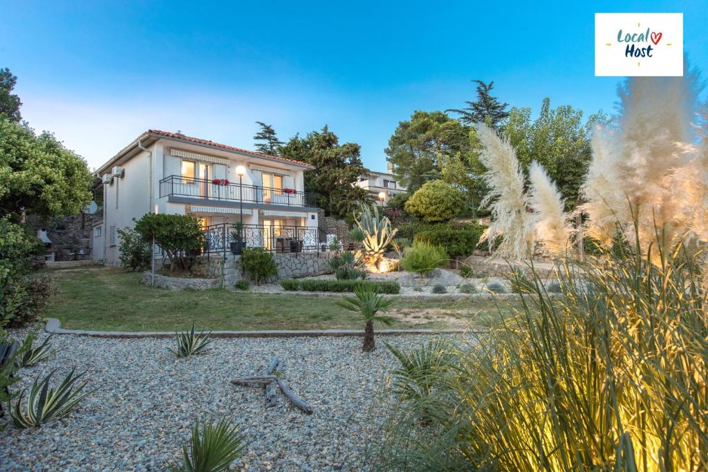 a house with a garden in front of it at Apartment Alida in Krk