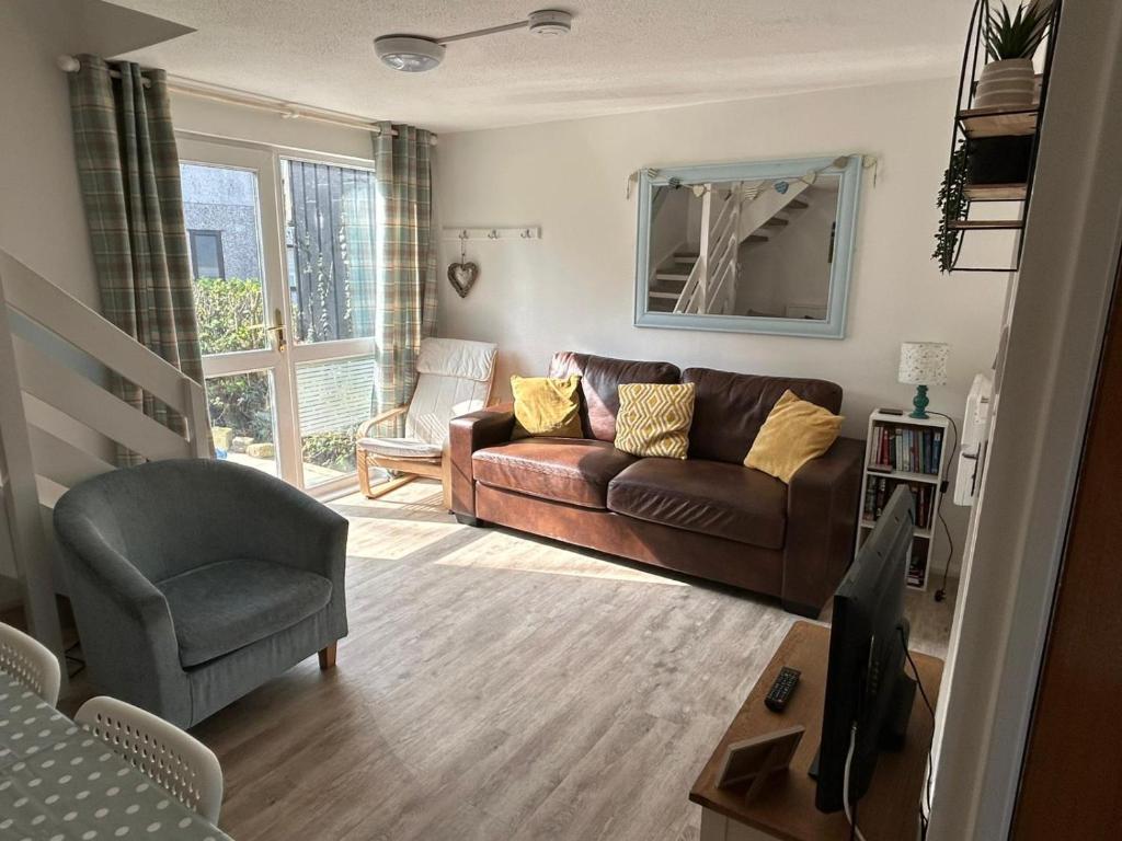 a living room with a couch and a chair at 20 Strawberry Hill cosy cottage sleeps 5 in Hayle