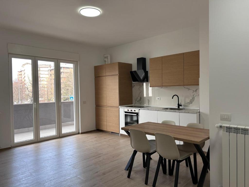a kitchen and dining room with a table and chairs at Nuvola Hosting in Segrate