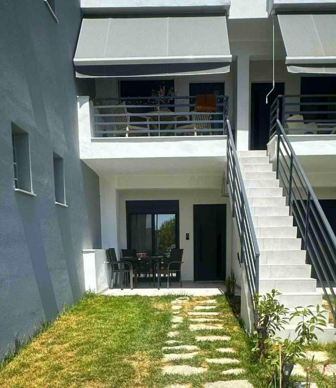 a house with stairs leading to a balcony with a table at Lemmy Аpartment in Ofrínion