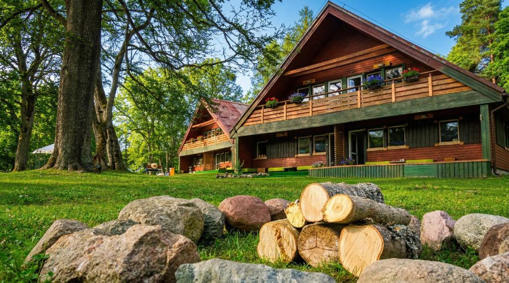 a house with a pile of logs in front of it at Wilcze Schronisko in Czerniki