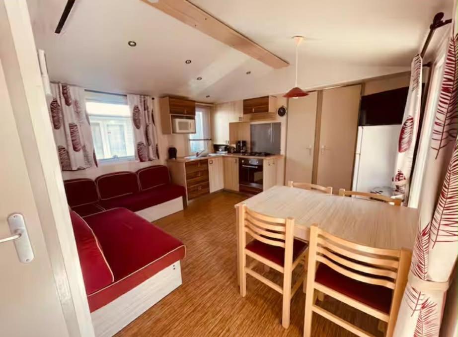 a kitchen and living room with a table and a couch at Au Valras plage in Sérignan