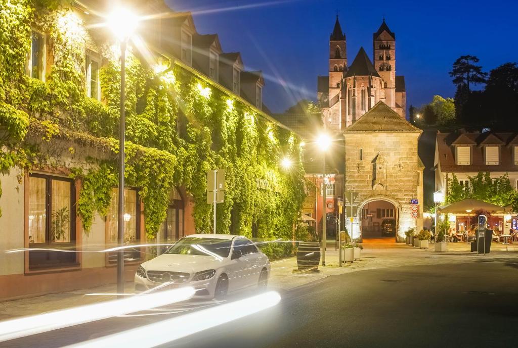 a white car parked on a street at night at Kaiserstühler-Hof in Breisach am Rhein