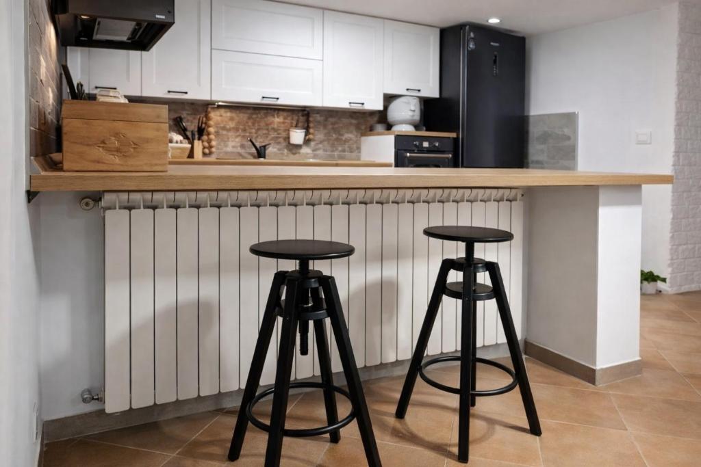 a kitchen with two bar stools at a counter at Casa Maria in Scauri