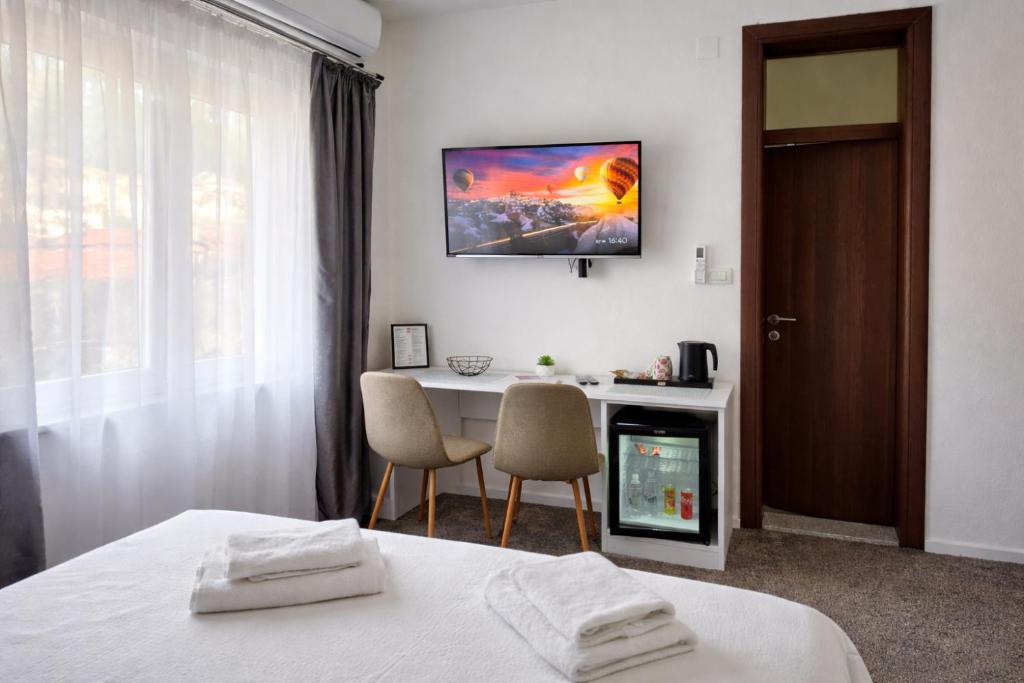 a hotel room with a bed and a table and chairs at Apartments Miš in Trebinje