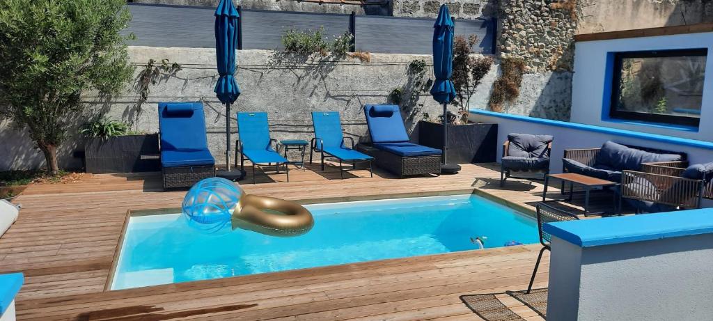 a swimming pool with blue chairs and a slide at La Moustache Bleue in Bouin
